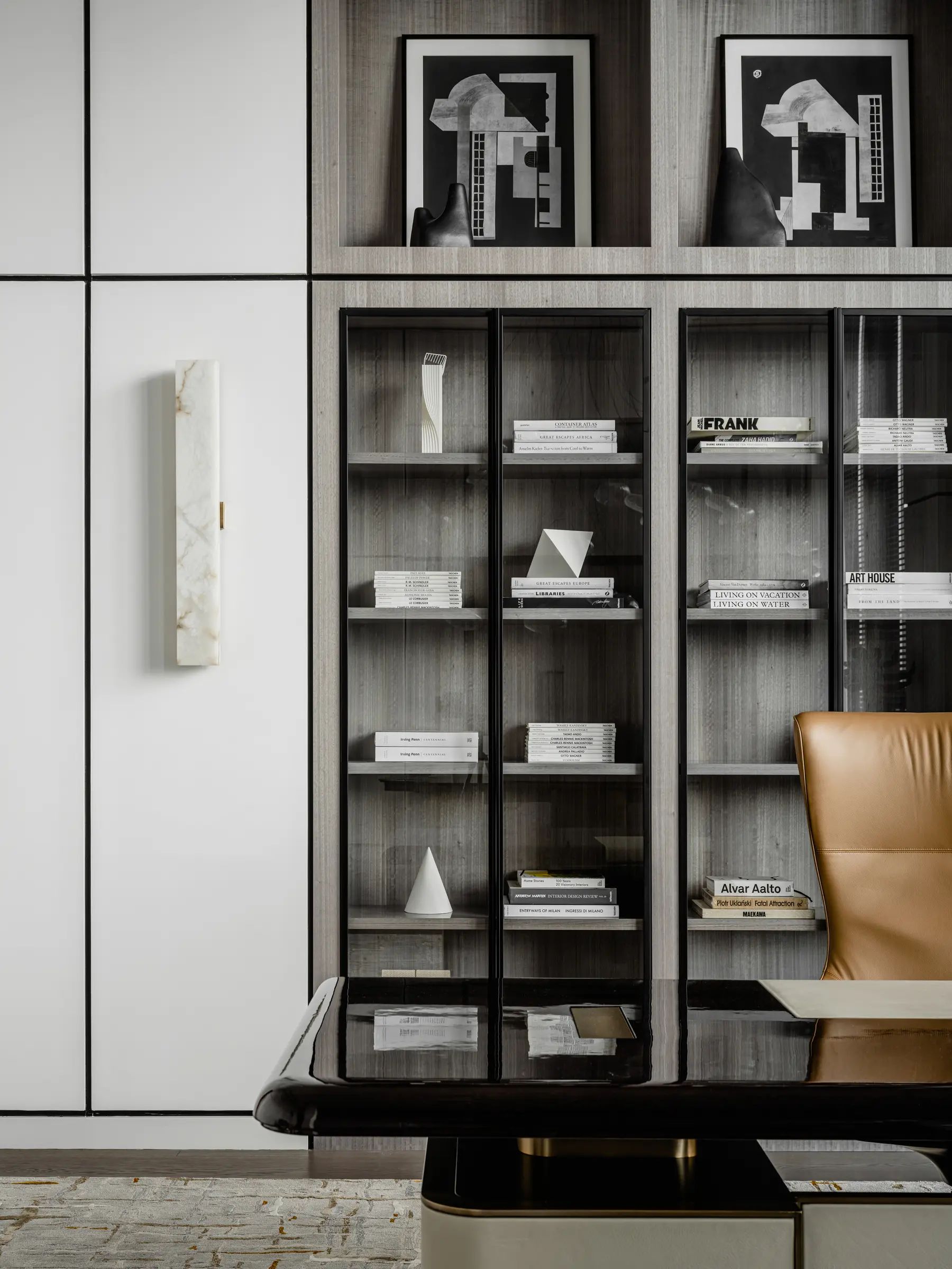 Shelving with artwork and an armchair in the private office